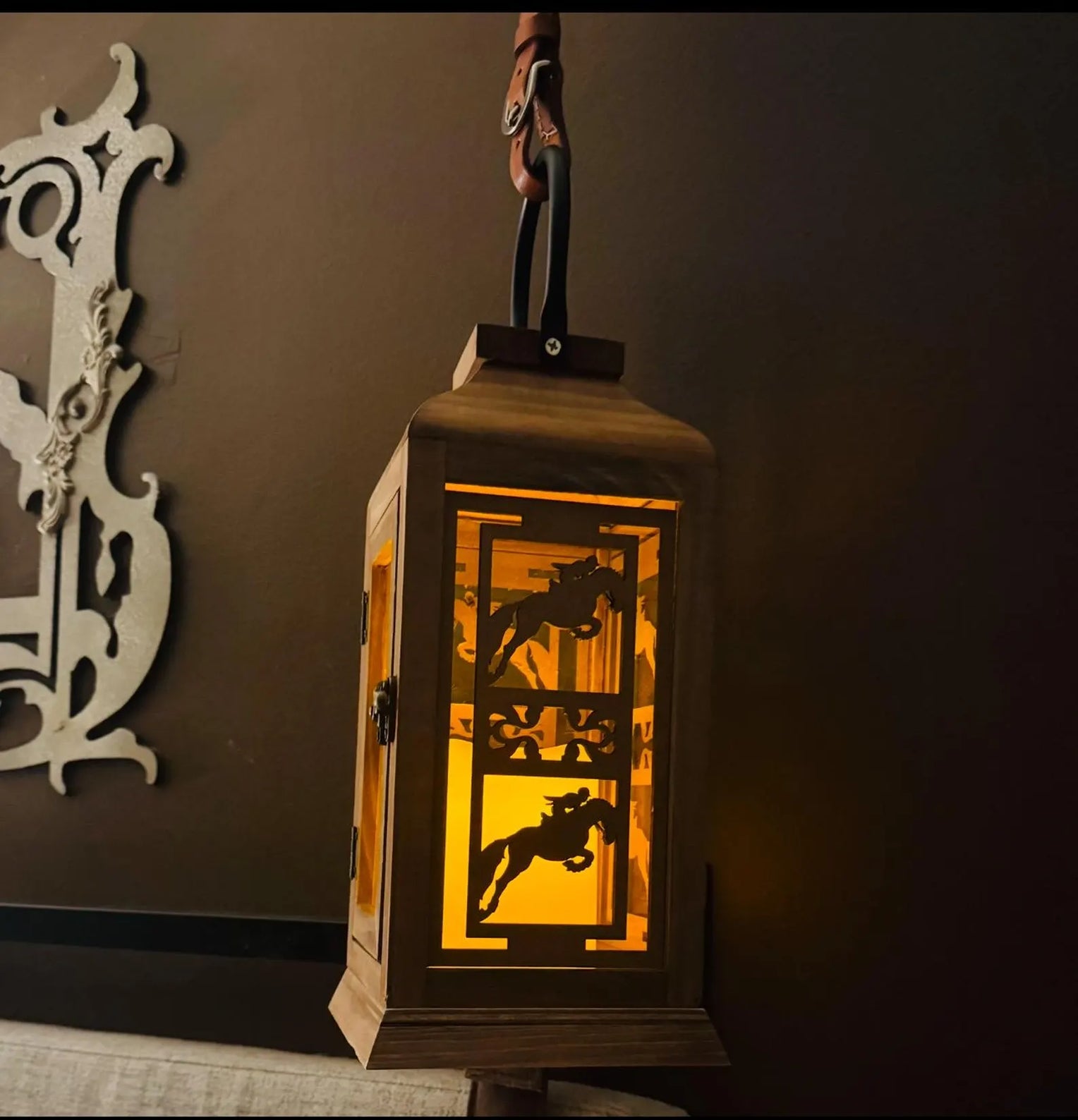 Side view of the jumping All Designs Equine Horse Lantern hanging on a brown wall
