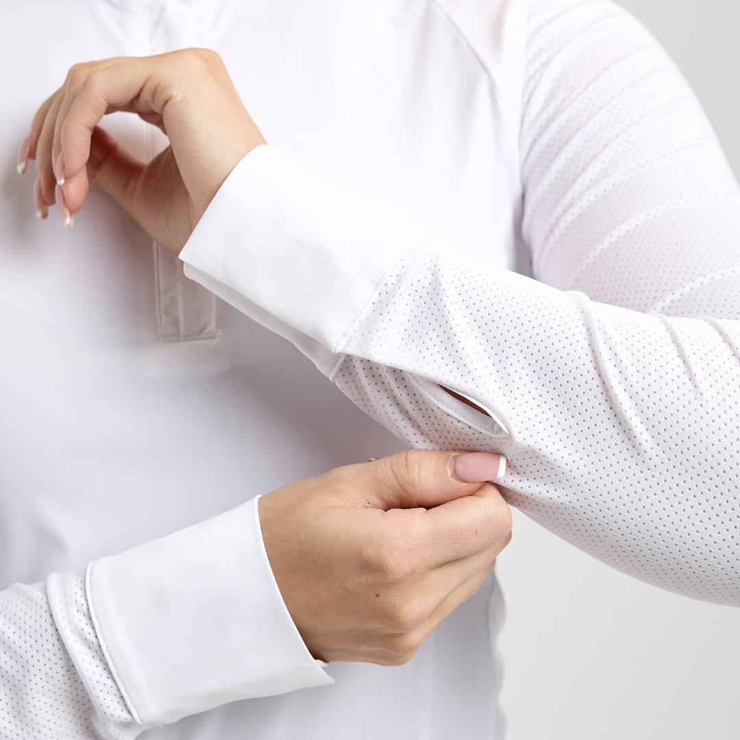 Close-up view of a female model showing the cuffs on the white TKEQ Sloan Competition Long Sleeve Top