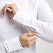 Close-up view of a female model showing the cuffs on the white TKEQ Sloan Competition Long Sleeve Top