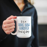 View of a model holding the Canary Road Horse Show Hangover Coffee Mug