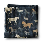 Front view of a folded navy horses Canary Road Kitchen Towel on a white background