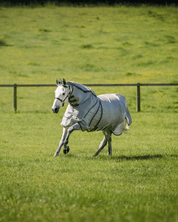 Horse running in a field wearing Horseware Rambo Optimo Protector Plus fly sheet in Silver/Thunderstorm Grey & Silver
