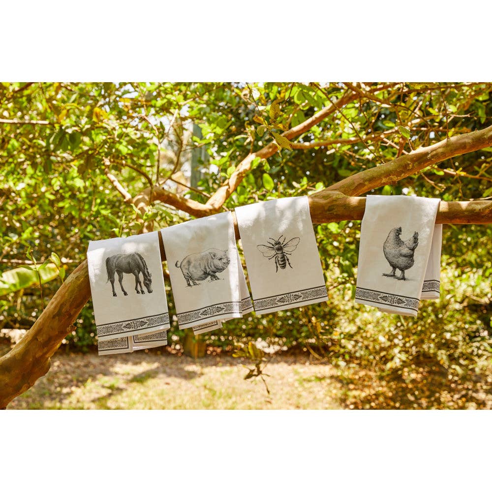 View of various designs of the Blue Stallion Farm Black & White Tea Towels hanging on a branch outside