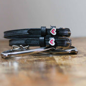 Front view of the buckled Heart Smooshes Mane Jane Spur Straps on wood