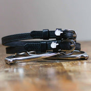 Front view of the buckled Middle Finger Mane Jane Spur Straps on wood