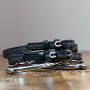 Front view of the buckled Horse Shoe Party Mane Jane Spur Straps on wood