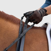 Close-up of a person riding a horse with a pair of black Correct Connect Thumb Grip Reins in their hands