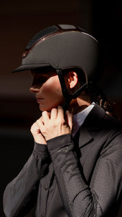 Side view of a female model wearing the black everyrose Kask Dogma Chrome Helmet
