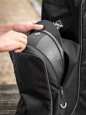 Close-up of hand pulling out a helmet from a LeMieux Elite Pro Boot and Hat Bag in black