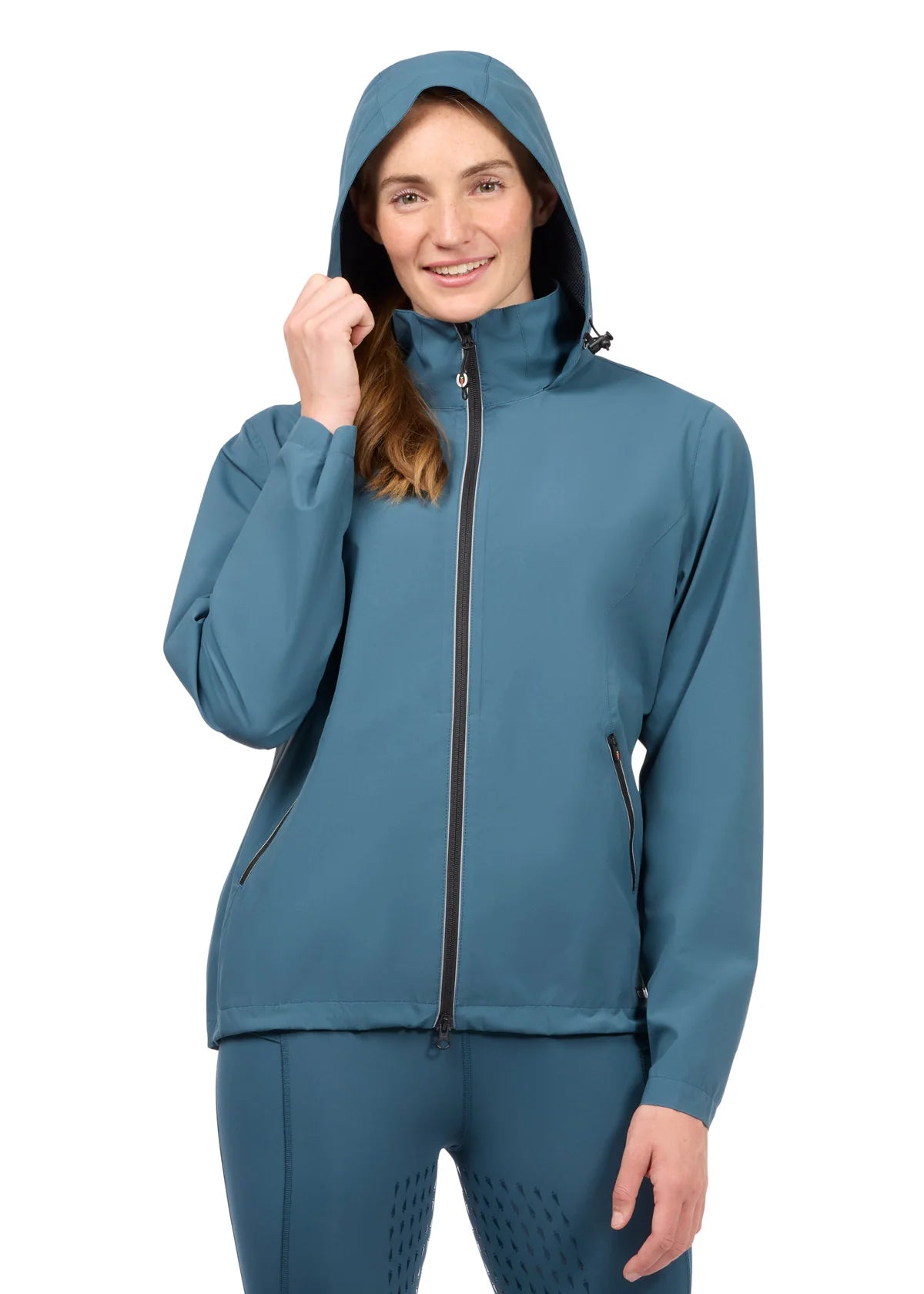 Woman wearing a teal waterproof jacket with hood up