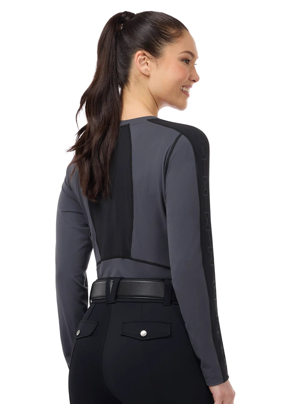 Back view of a female model wearing the Carbon Kerrits Bit of Base Layer Top on a plain background