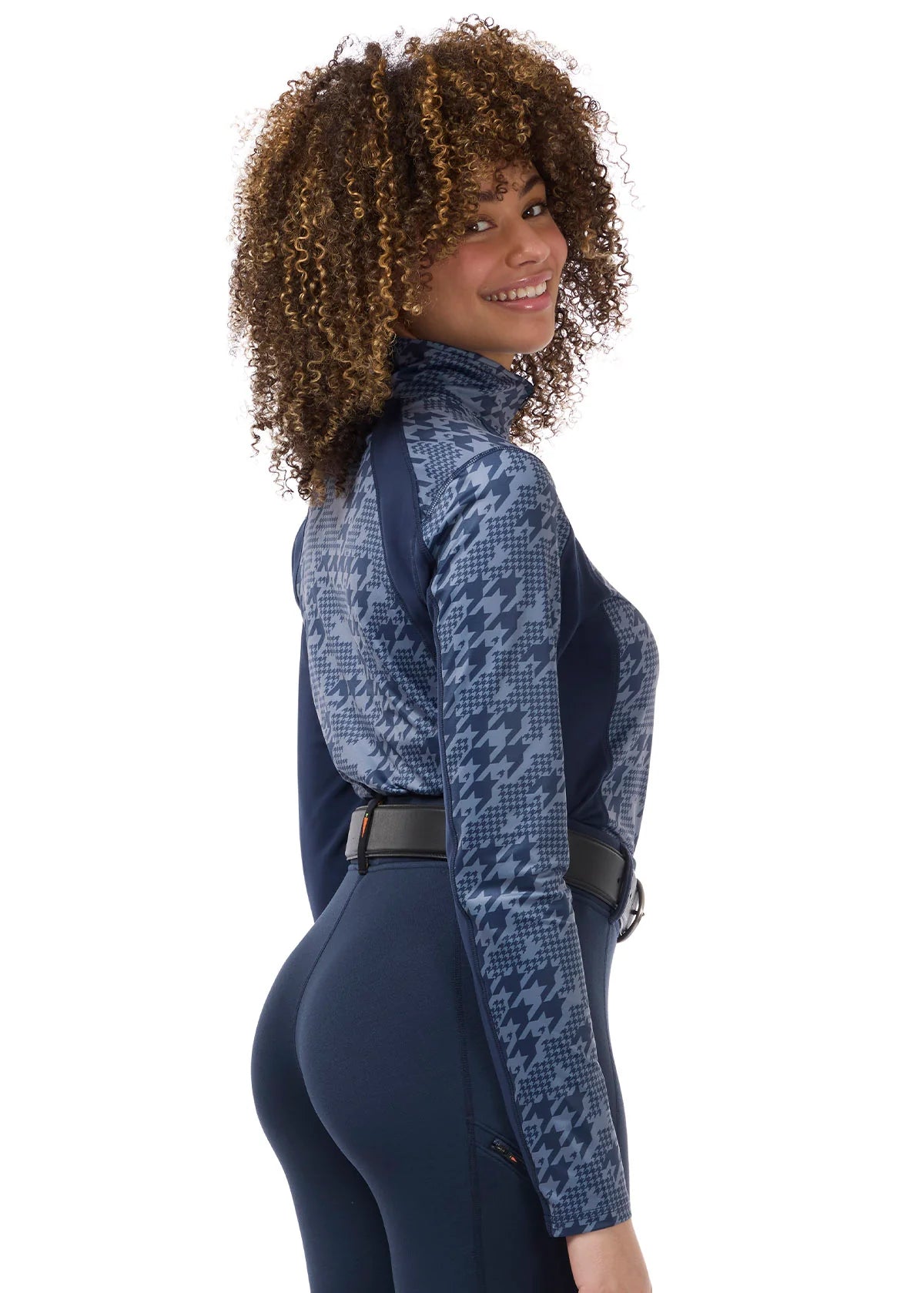 Angled back view of a female model wearing the Dusty Blue Kerrits Traverse Quarter Zip Fleece Tech Top on a plain background