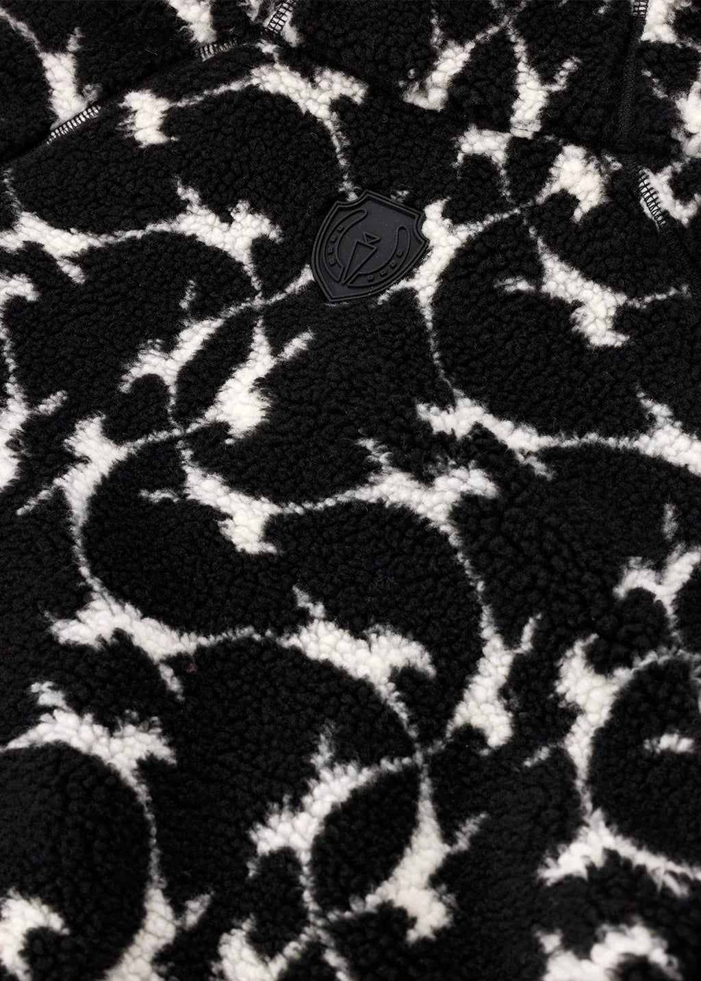 Close-up view of the pattern and logo on the Black Kerrits Berber Flying Horse Jacket