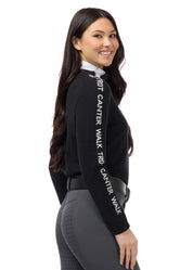 Side view of a female model wearing the Black/White Kerrits Equi Rhythm Crew Neck Sweater on a plain background