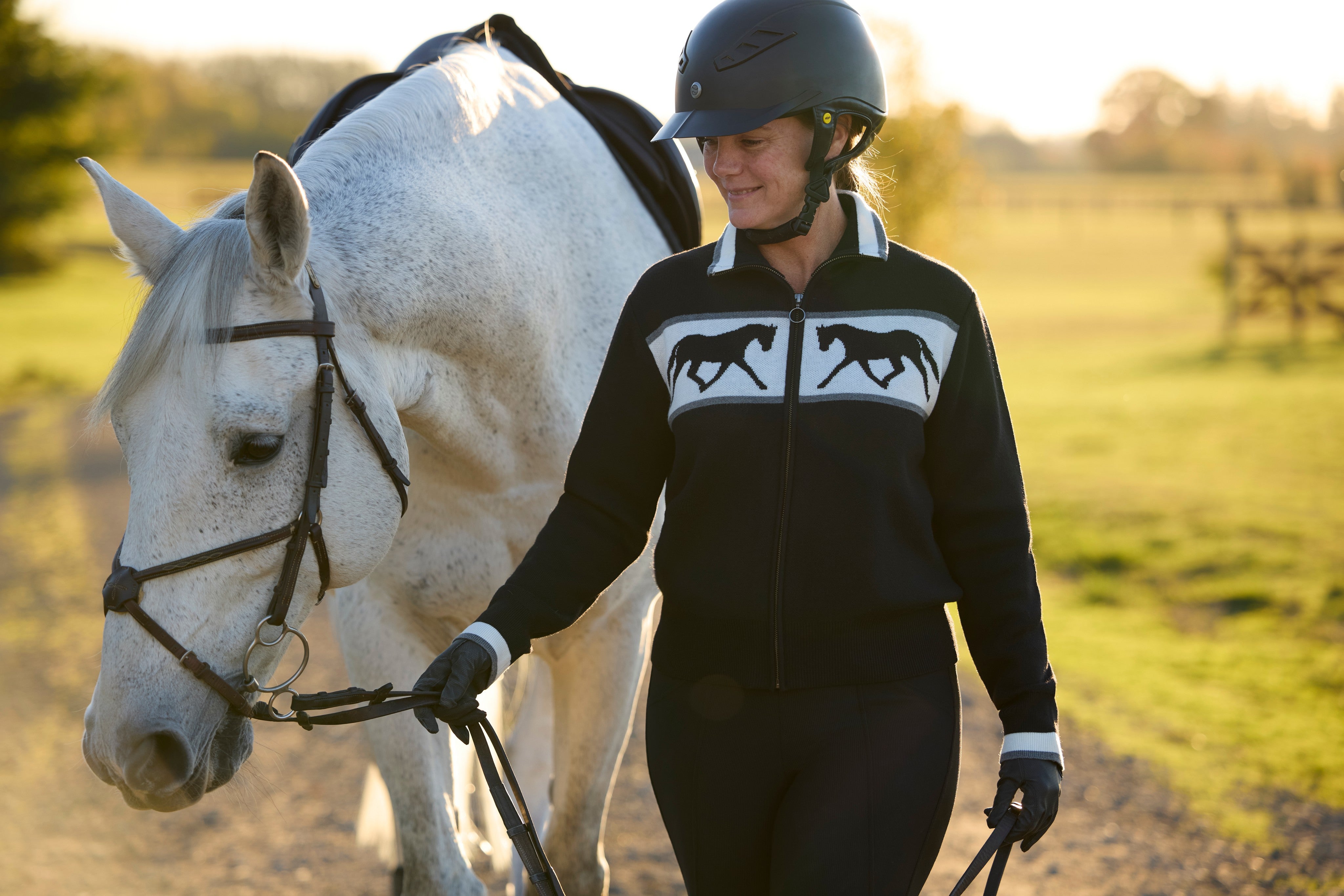 Front view of a model wearing Black Kerrits Reflections Full Zip Sweater
