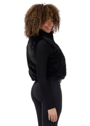 Side view of a model wearing Black Kerrits Skyline Houndstooth Reversible Vest showing the reversible side on a white background