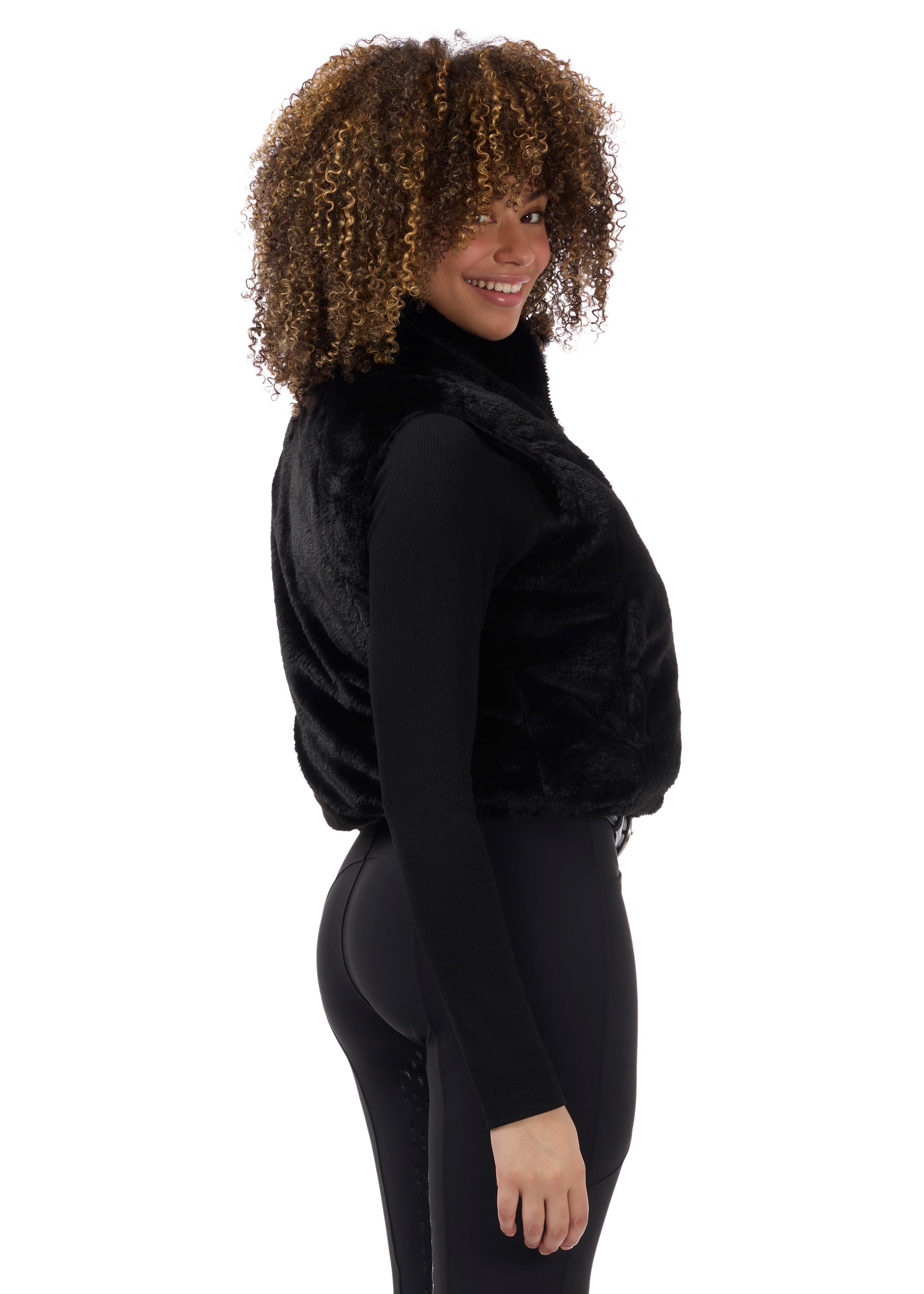 Side view of a model wearing Black Kerrits Skyline Houndstooth Reversible Vest showing the reversible side on a white background