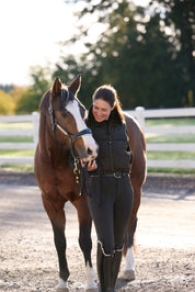 Front view of a model wearing Black Kerrits Skyline Houndstooth Reversible Vest