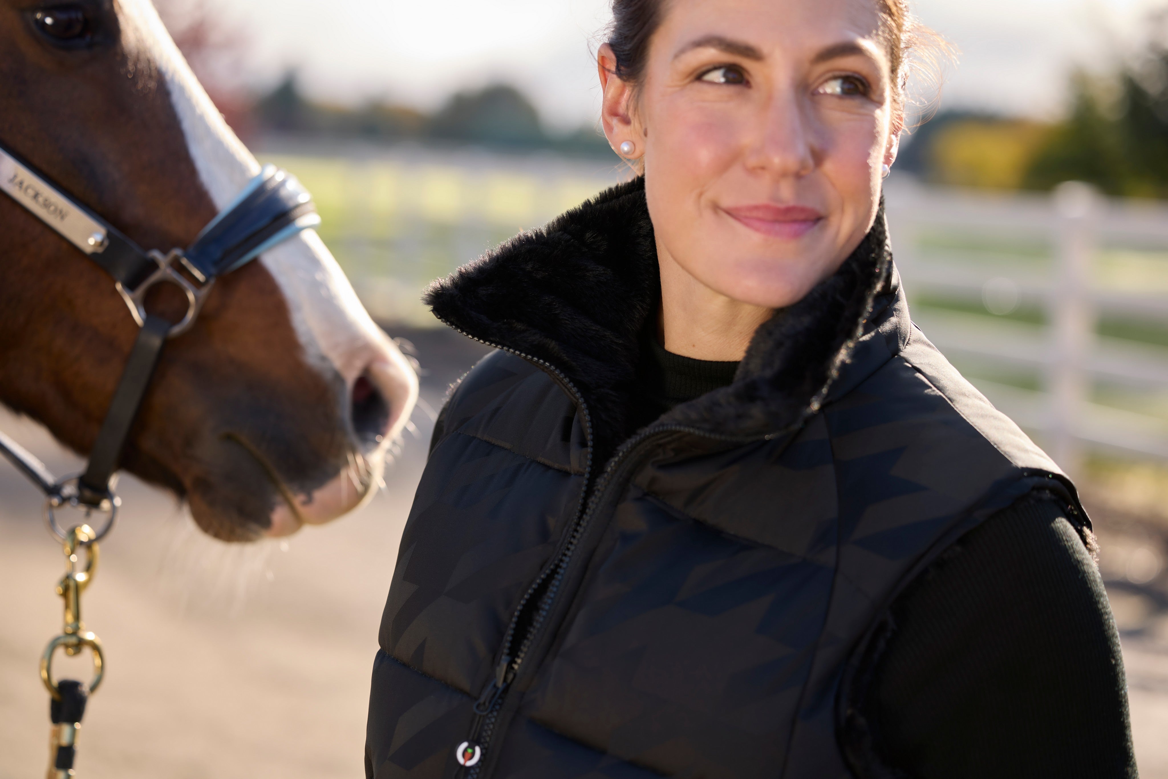 Angled front closeup view of a model wearing Black Kerrits Skyline Houndstooth Reversible Vest