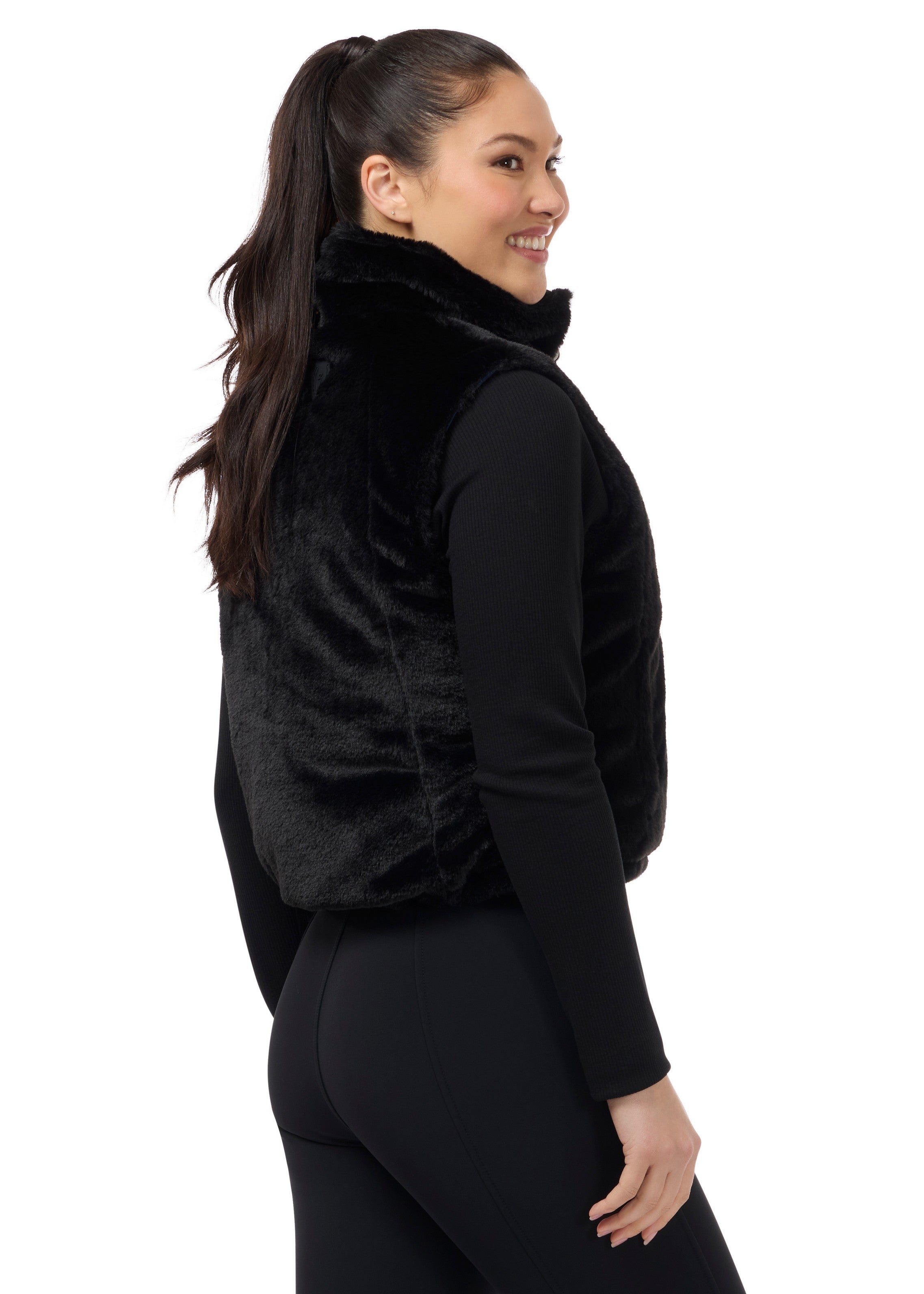 Angled back view of a model wearing Nightfall Kerrits Skyline Houndstooth Reversible Vest showing the reversible side on a white background