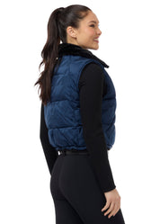 Angled back view of a model wearing Nightfall Kerrits Skyline Houndstooth Reversible Vest on a white background