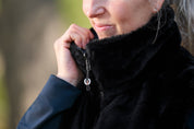 Front closeup view of a model wearing Nightfall Kerrits Skyline Houndstooth Reversible Vest showing the reversible side