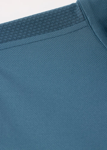Close-up of teal fabric texture on the shirt