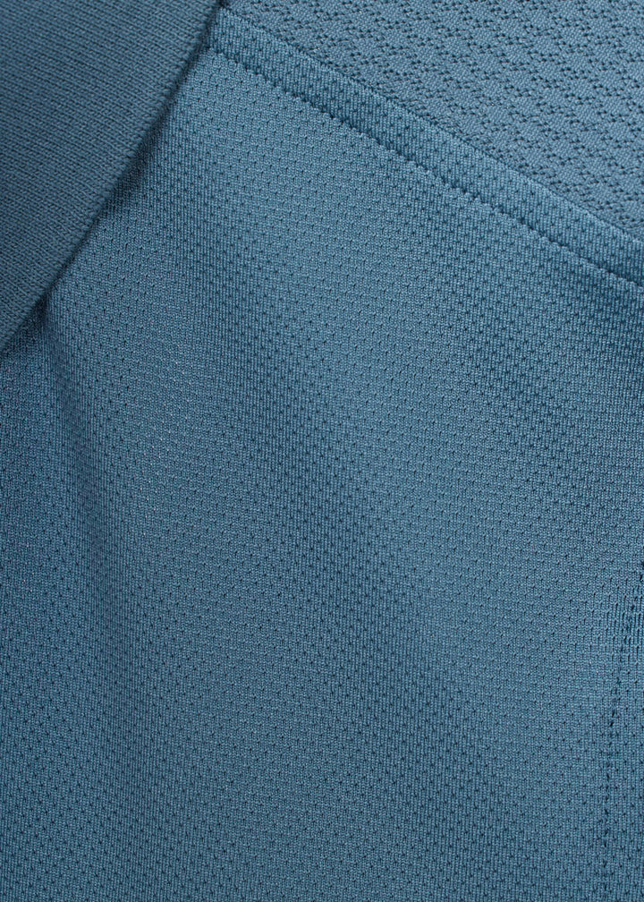 Close-up of muted blue fabric texture on the polo shirt