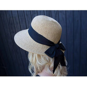 Side view of a model wearing the Dorfman Milano Riviera Hat on a blue wood plank background