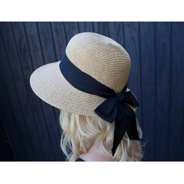 Side view of a model wearing the Dorfman Milano Riviera Hat on a blue wood plank background