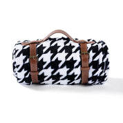 View of the rolled up Blue Stallion Farm Black & White Houndstooth Flannel Fleece Blanket in Leather Holder on a white background