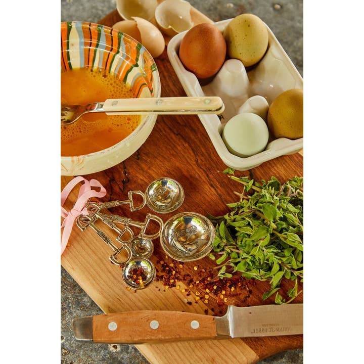 View of the Blue Stallion Farm Equestrian Zinc Measuring Spoons with eggs and spices on a wooden cutting board