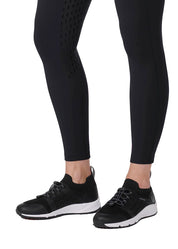 Close-up view of the lower leg on the black Kerrits Coolcore Full Leg Tech Tight on a white background