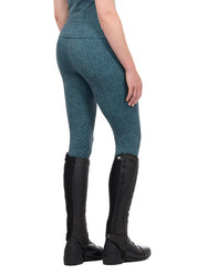 Woman wearing blue printed riding tights with tall boots, rear view