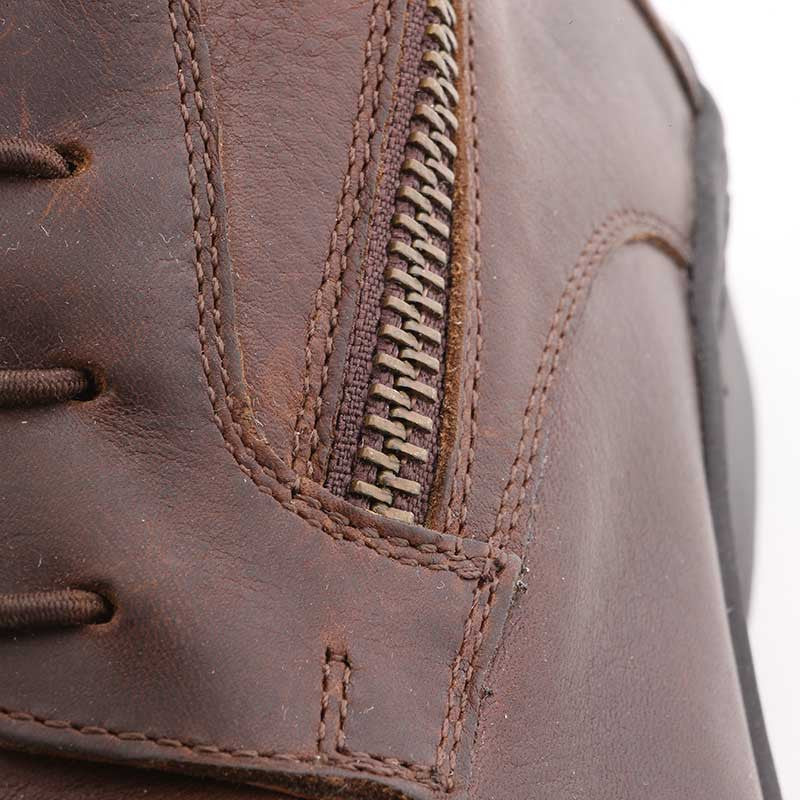 Close-up view of the zipper on a brown Kavalkade Romulus Oiled Leather Side Zip Paddock Boot