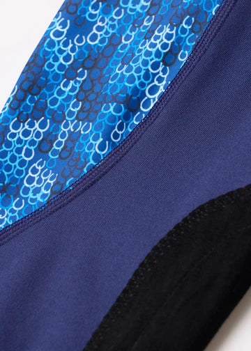 Close-up of blue patterned panel and black knee patch on navy tights
