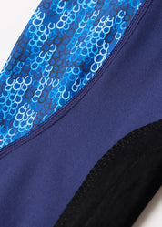 Close-up of blue patterned panel and black knee patch on navy tights