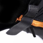 Close up view of the underside orange zip and black velcro closure on the Shires FlyGuard Pro Stretch Fly Mask in black