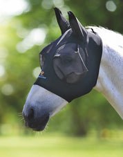 Side view of a gray horse standing outside wearing the Shires FlyGuard Pro Stretch Fly Mask in black 