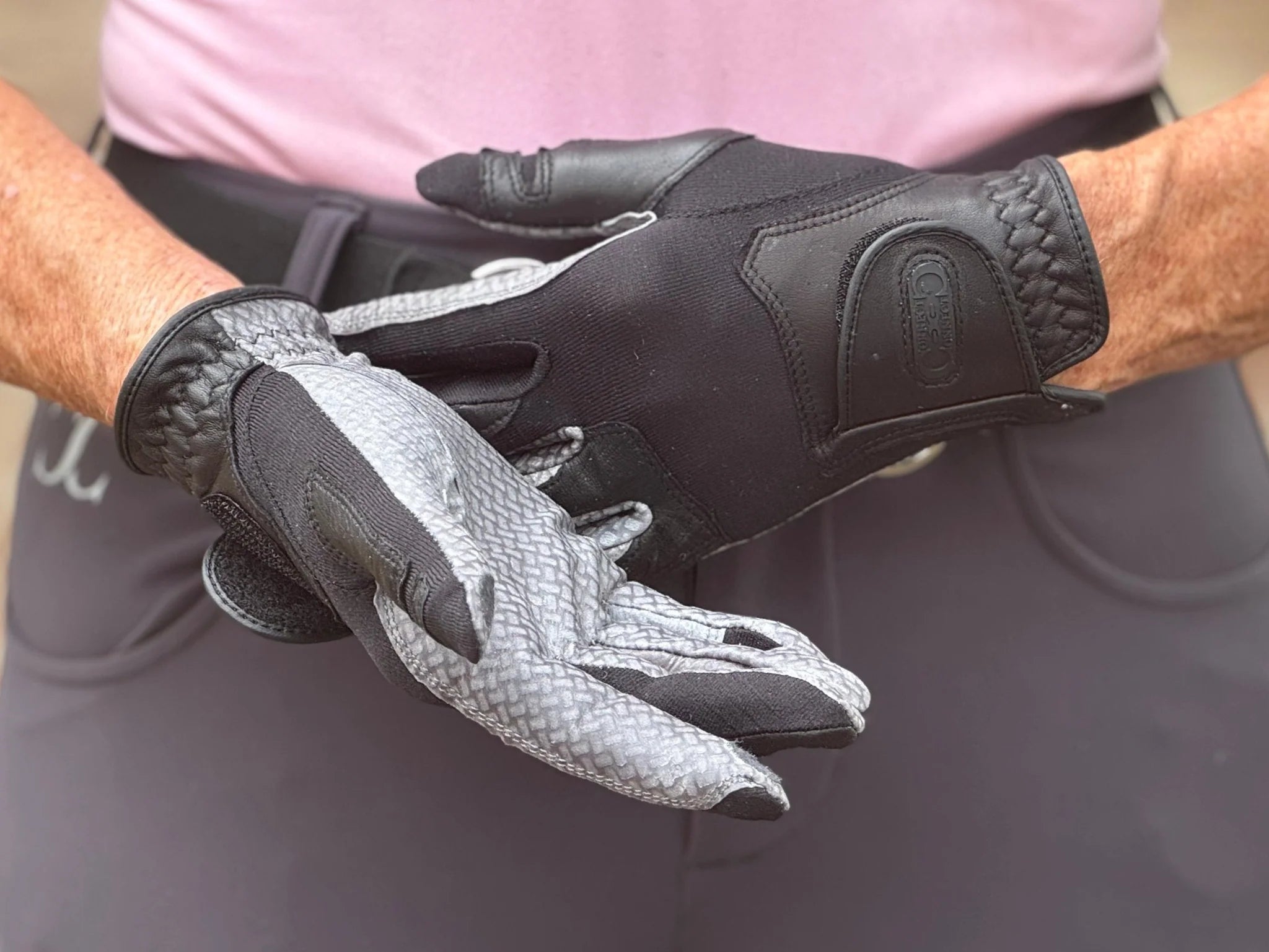 Close-up of a person wearing a pair of Correct Connect Oil-Tac Copper Tech™ Leather Premium Riding Gloves in black