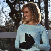 Front view of a woman standing outside and adjusting her black SSG All Weather Gloves