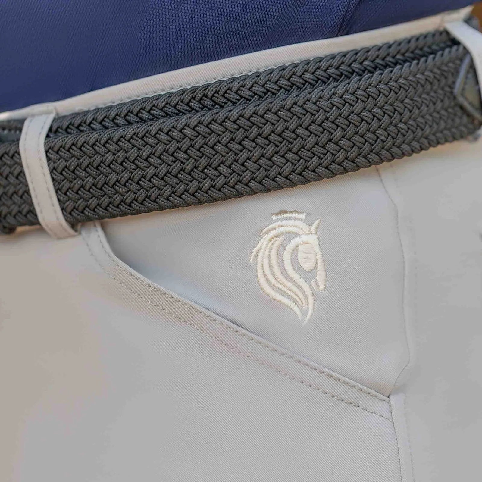 Close-up view of the logo near the front pocket on the  tan Equinavia Karl Men's Knee Patch Breeches