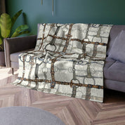 View of the All Designs Equine Ivory Bit Plaid Equestrian Crushed Velvet Throw on a gray couch