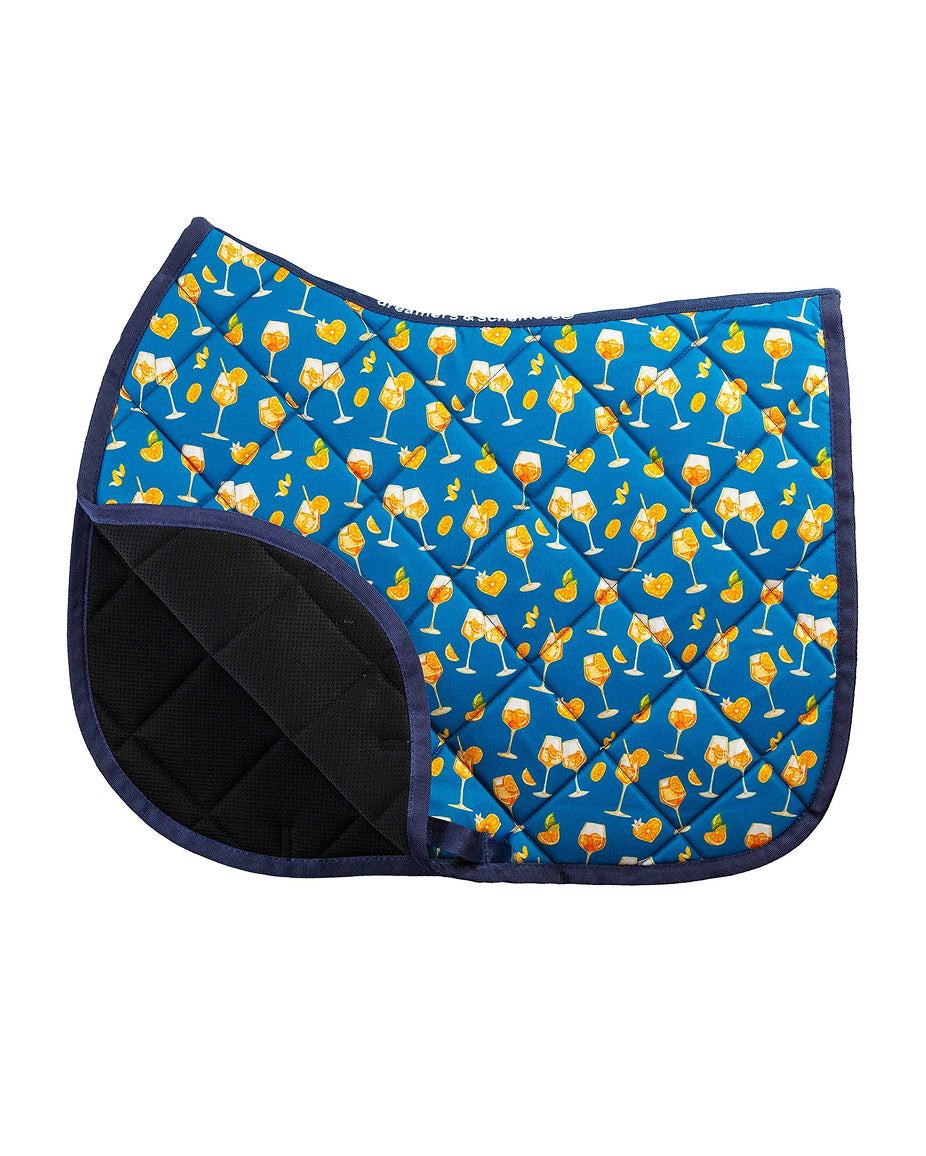 Side view of the Aperol Spritz Dreamers & Schemers Saddle Pad on a plain background with the corner turned up to show the mesh lining