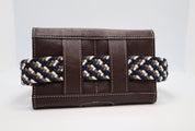 Back view of the brown KL Select Phone Pocket with a woven stretch belt through the loops on a plain background