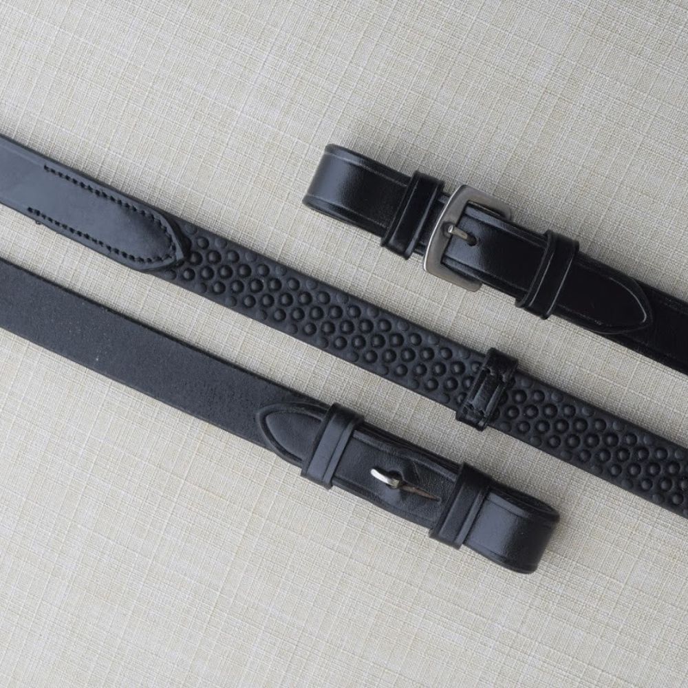 Side-by-side views of a the black Black Oak Pebble Grip Reins with Stops on a textured background