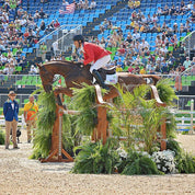 Rider jumping a horse over an obstacle with Majyk Equipe Boyd Martin leather tendon boots on the front legs