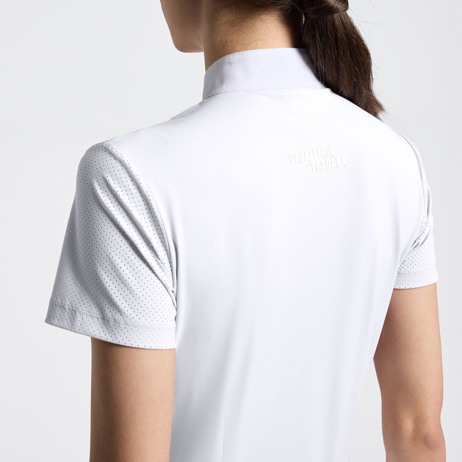 Close-up back view of a model wearing the white Cavalleria Toscana Perforated Short Sleeve Competition Shirt on a plain background