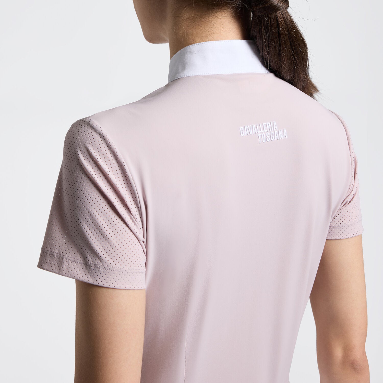 Close-up back view of a model wearing the pink Cavalleria Toscana Perforated Short Sleeve Competition Shirt on a plain background