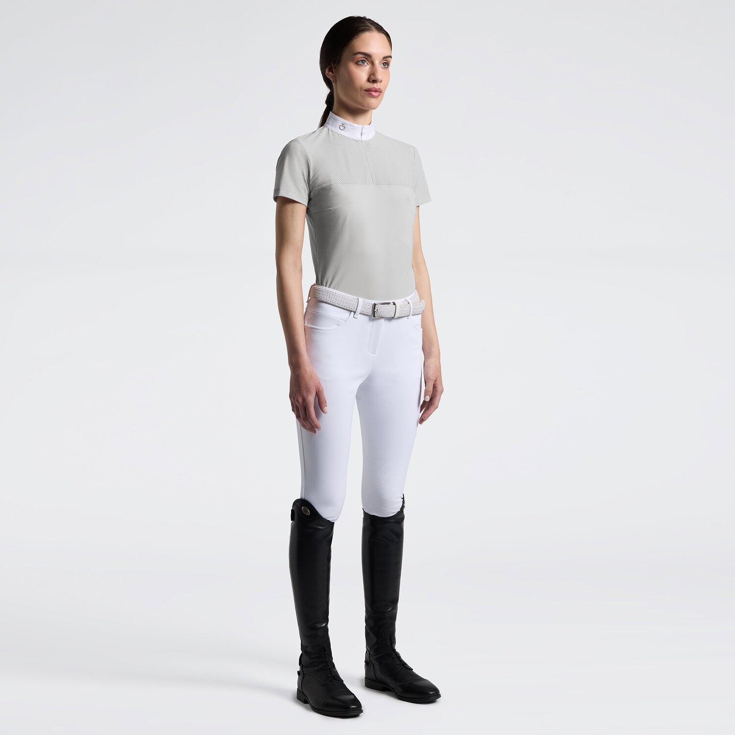 Full body front view of a model wearing the gray Cavalleria Toscana Perforated Short Sleeve Competition Shirt and white breeches on a plain background